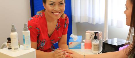 A nail salon with a client and a nail technician.