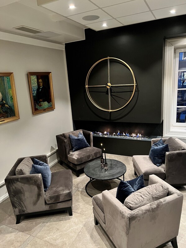 A modern living room with sofas, a coffee table, and a fireplace. - Wilhelmsen house Apartments (Tønsberg)