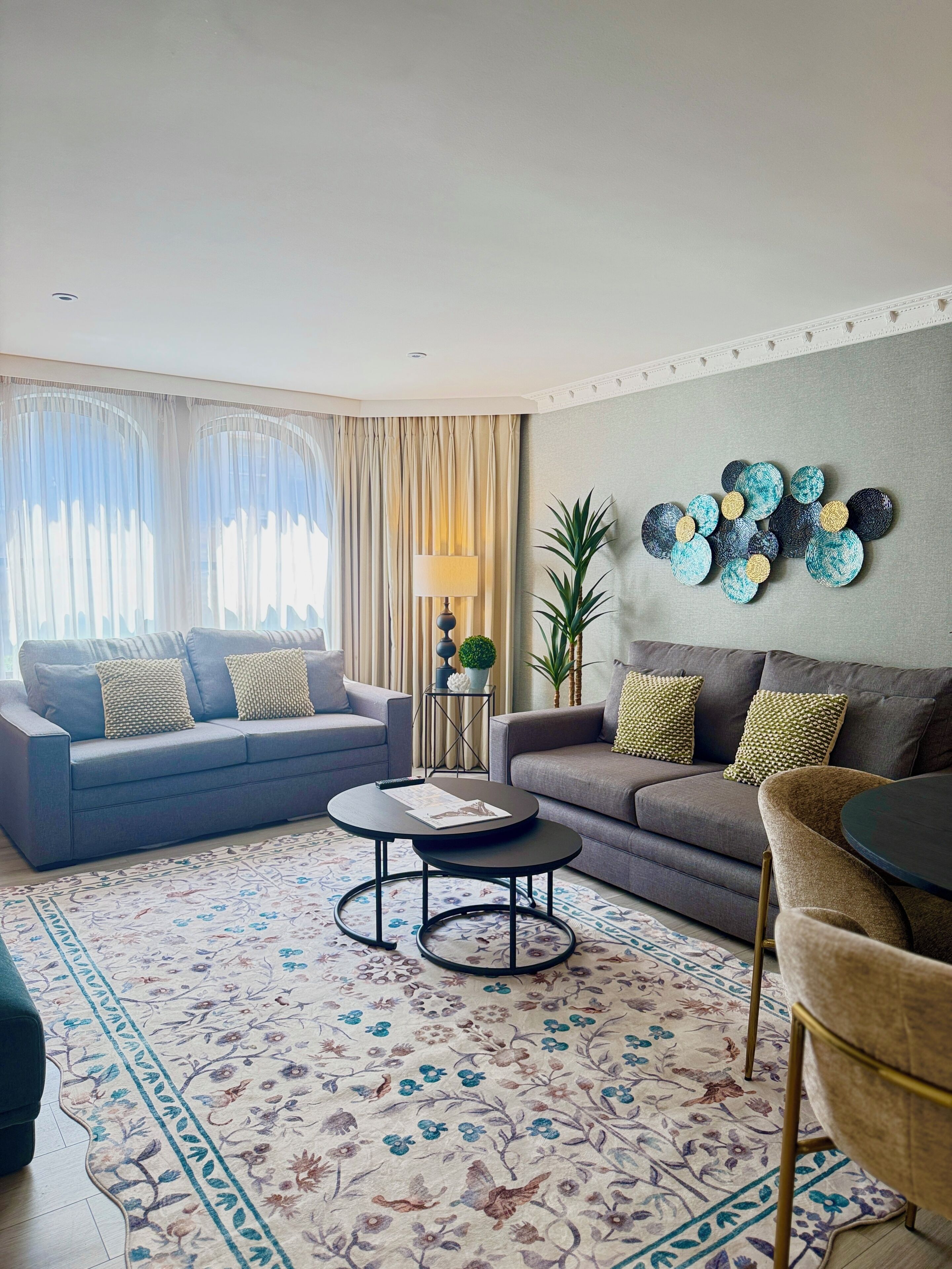A modern living room with a sofa, armchair, coffee table, and decorative wall art.