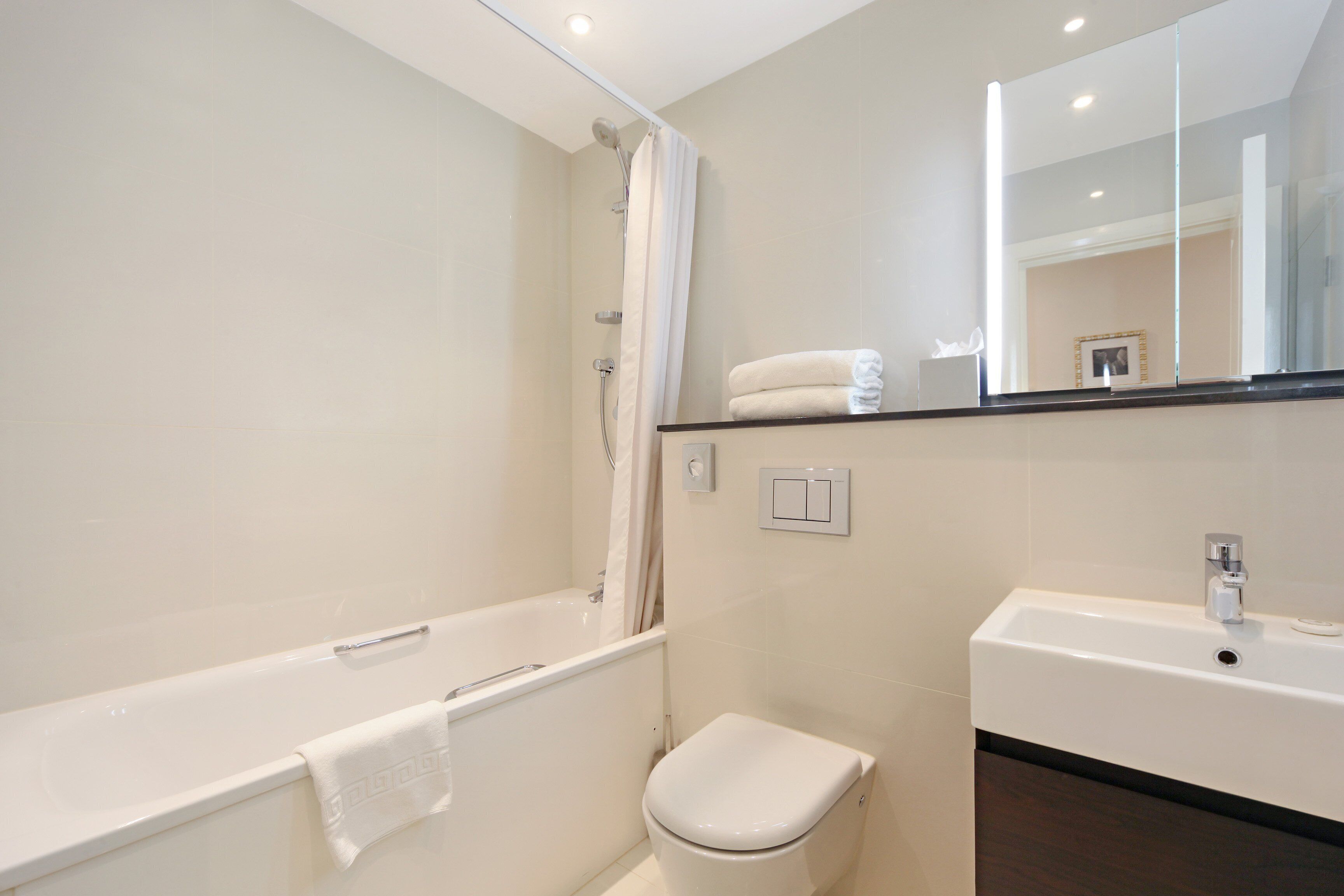Un baño moderno con bañera, inodoro y lavamanos.