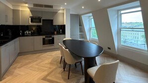 Una cucina moderna con zona pranzo, ampie finestre e vista sulla città.