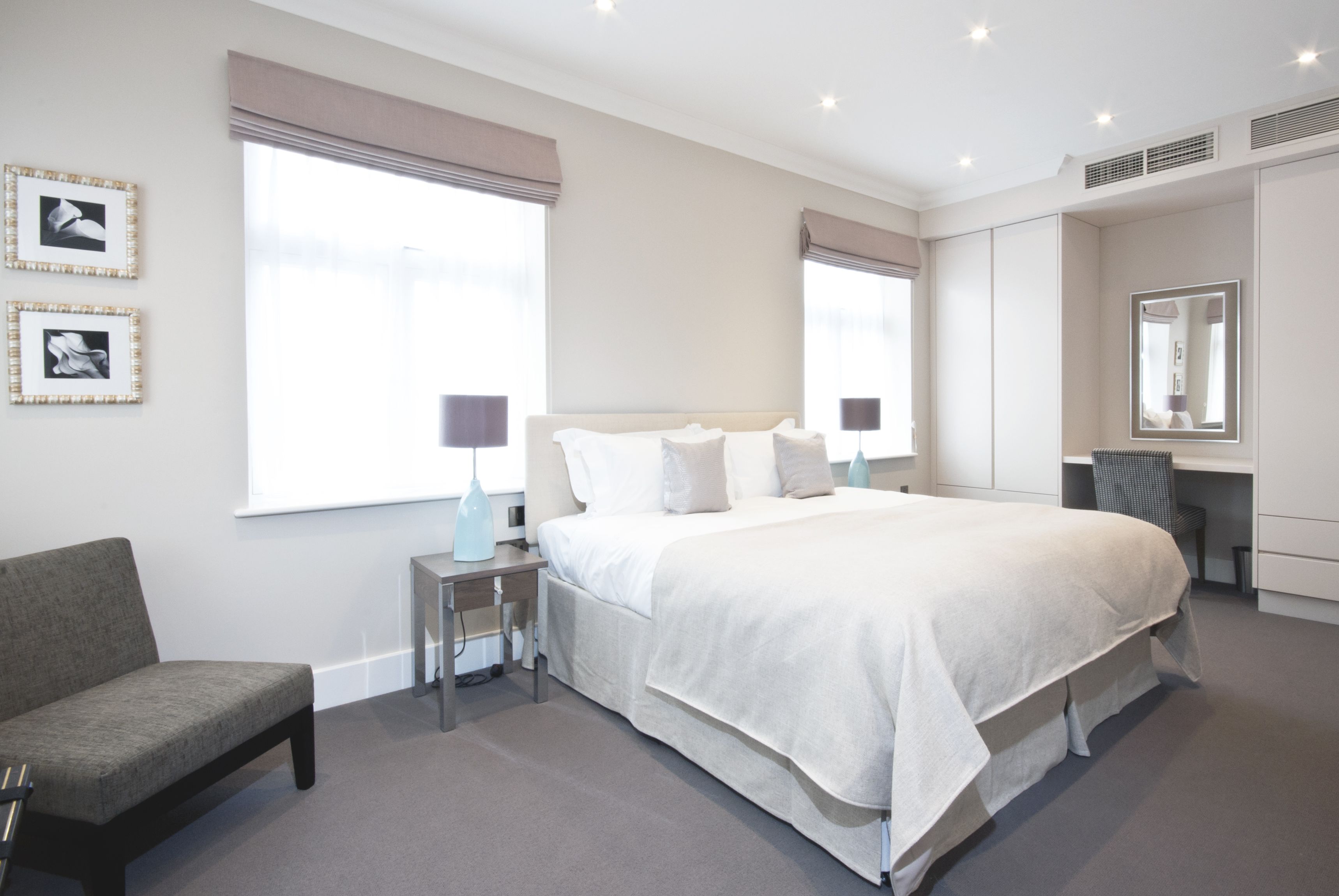 Une chambre d’hôtel moderne avec un grand lit, des tables de chevet, une chaise et un bureau.