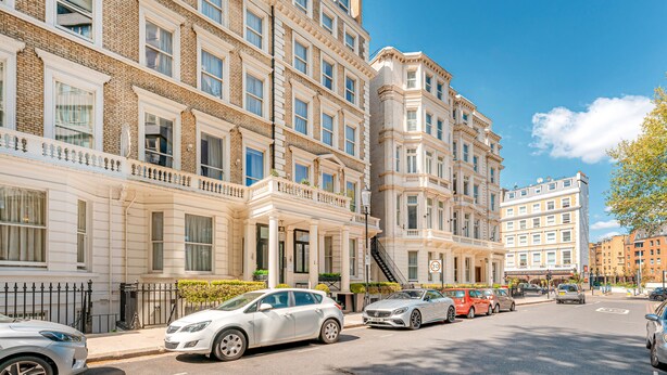 Un edificio a più piani dallo stile architettonico classico, con ampie finestre e un ingresso d'angolo ben evidente.
