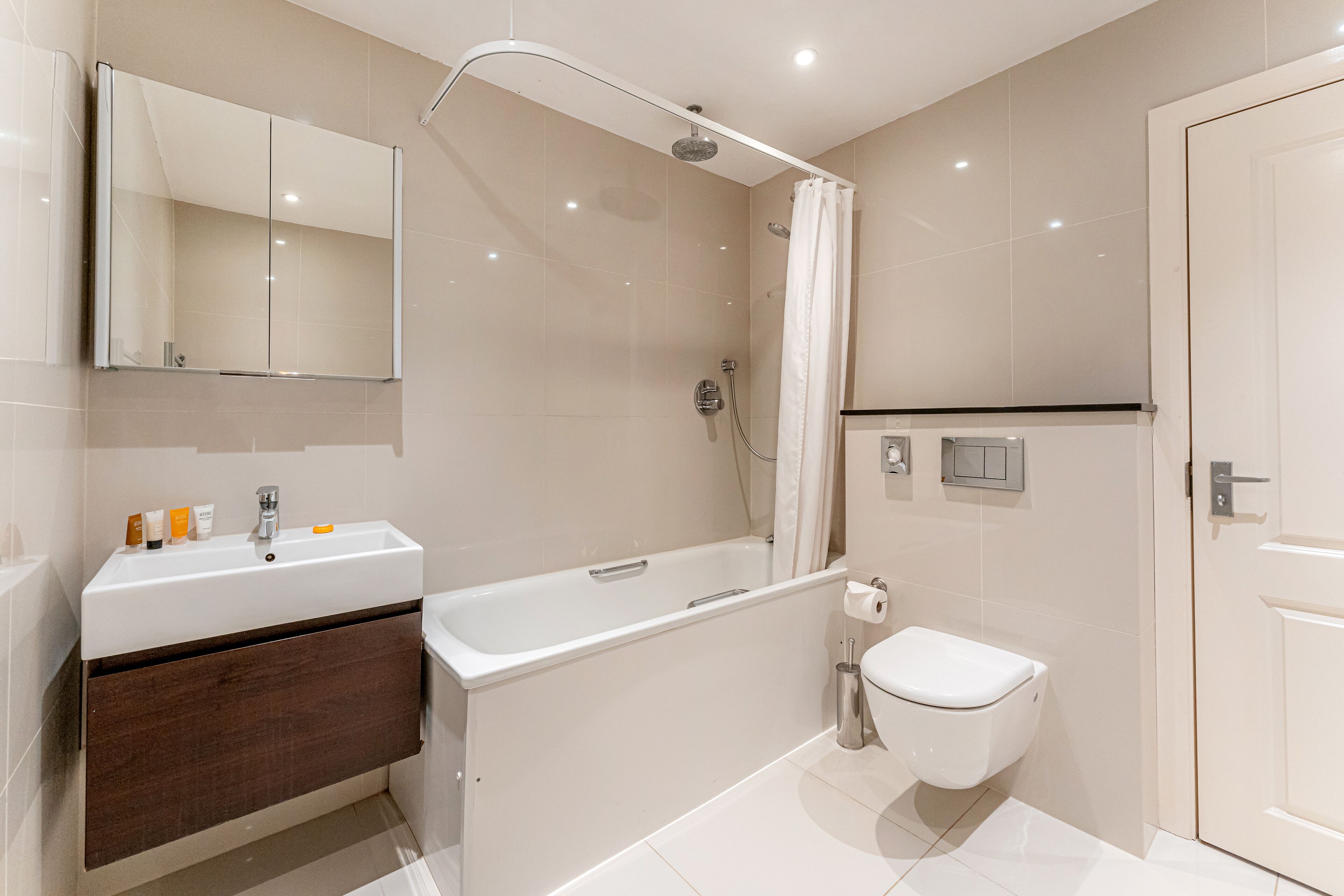 Un baño moderno con ducha, inodoro y lavamanos.