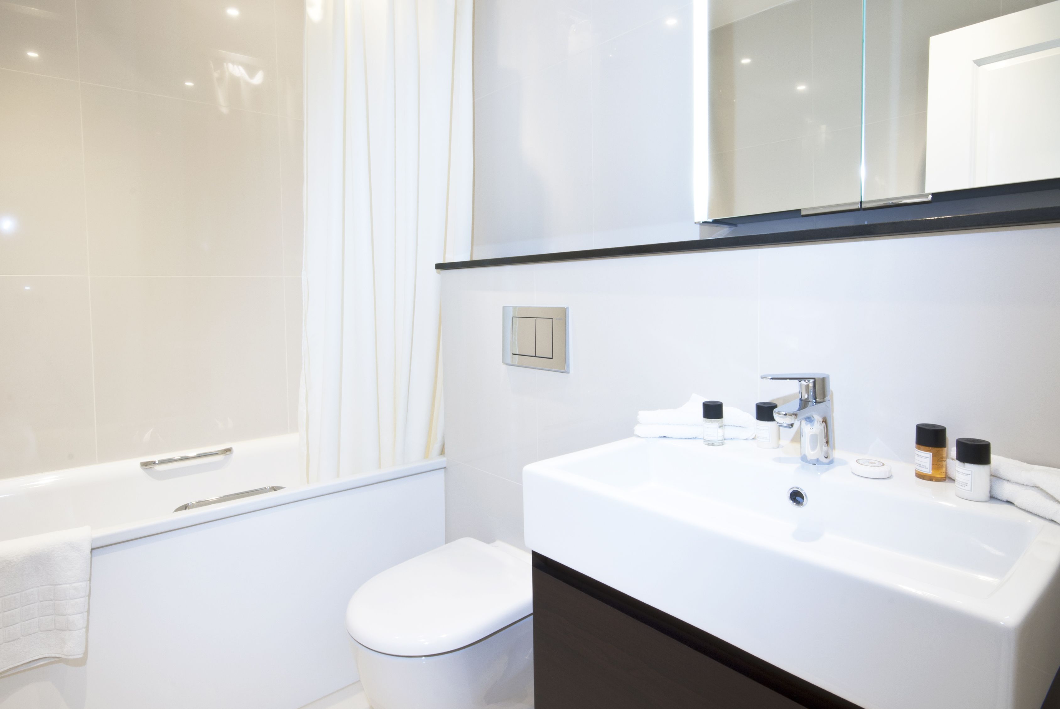 A modern bathroom with a bathtub, toilet, and sink.
