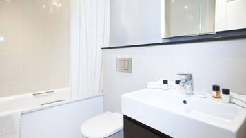 A modern bathroom with a bathtub, toilet, and sink.