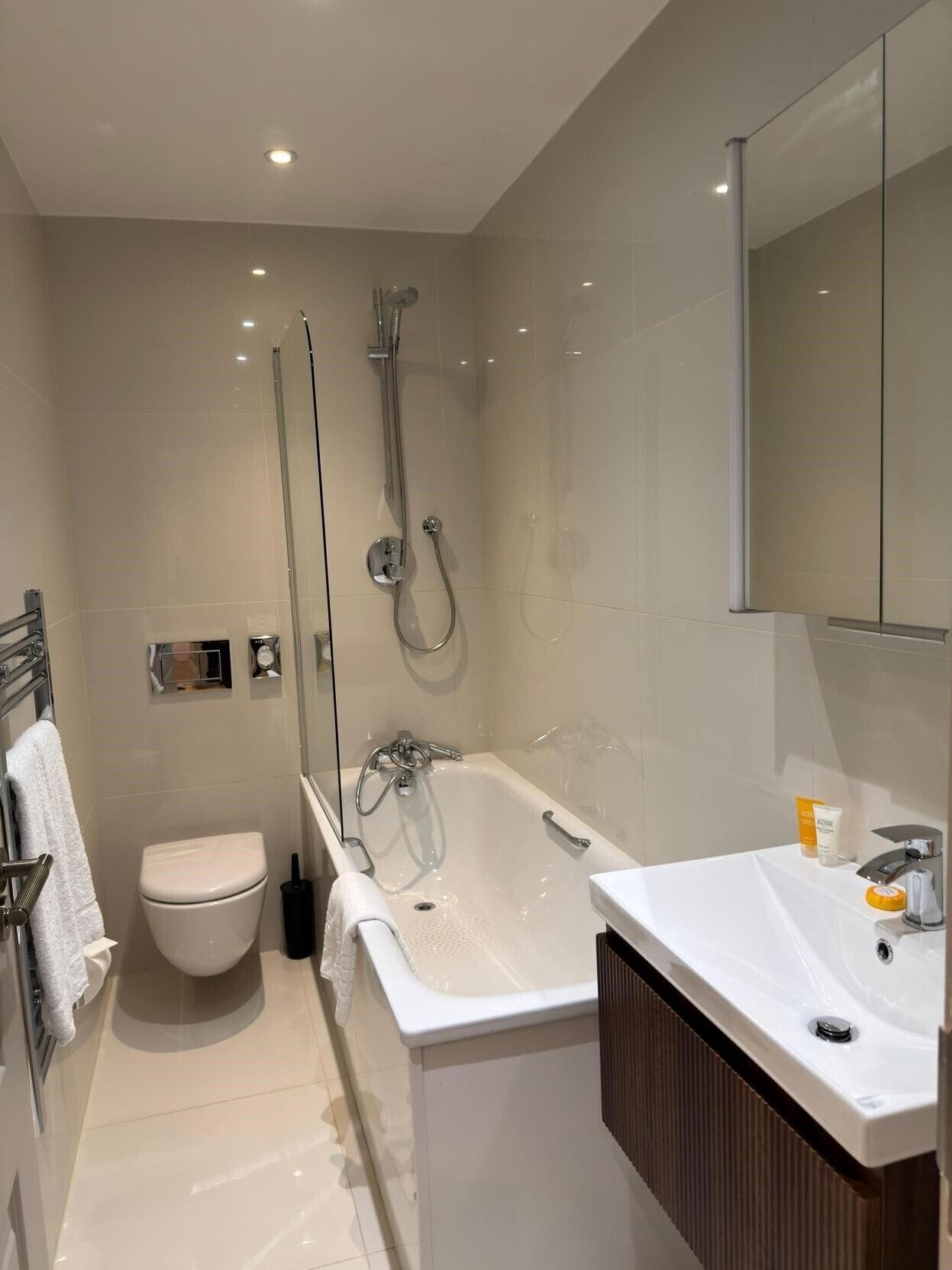 A modern bathroom with a shower, toilet, and sink.