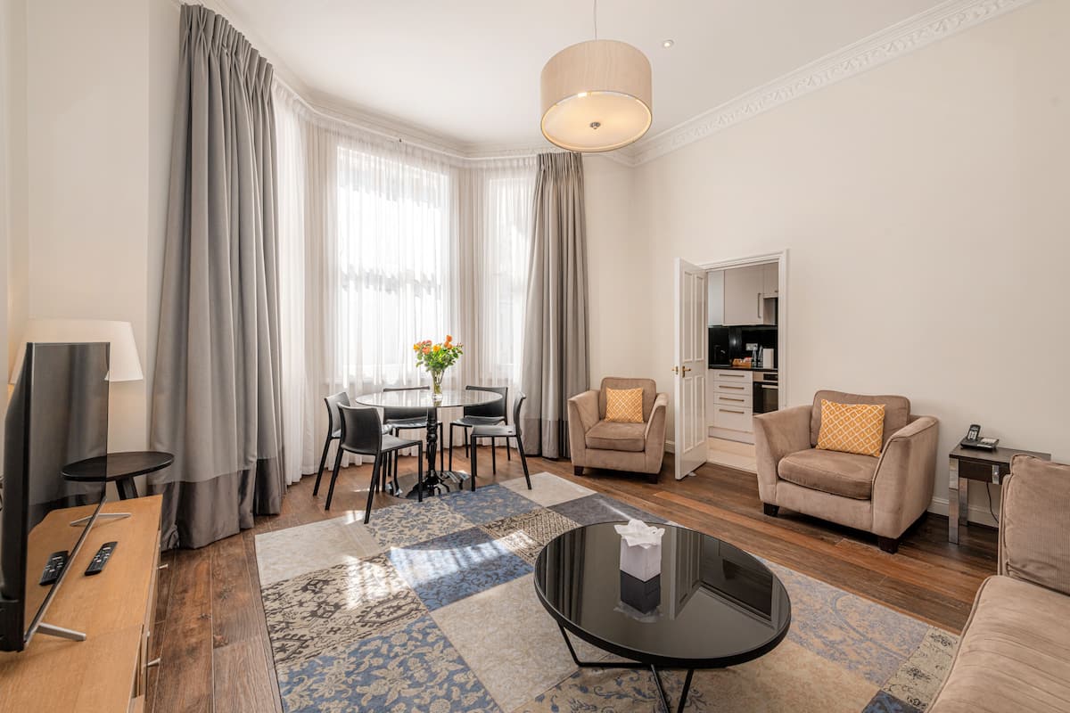 Apartamento Deluxe, 2 habitaciones | Zona de estar | Una televisión de pantalla plana, un reproductor de DVD