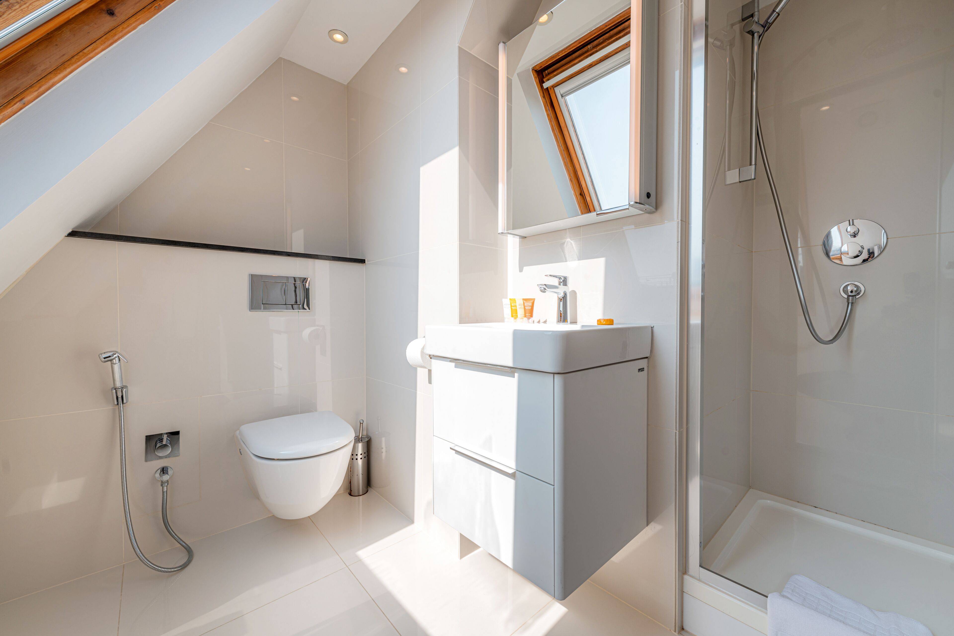 A modern bathroom with a shower, toilet, and vanity.