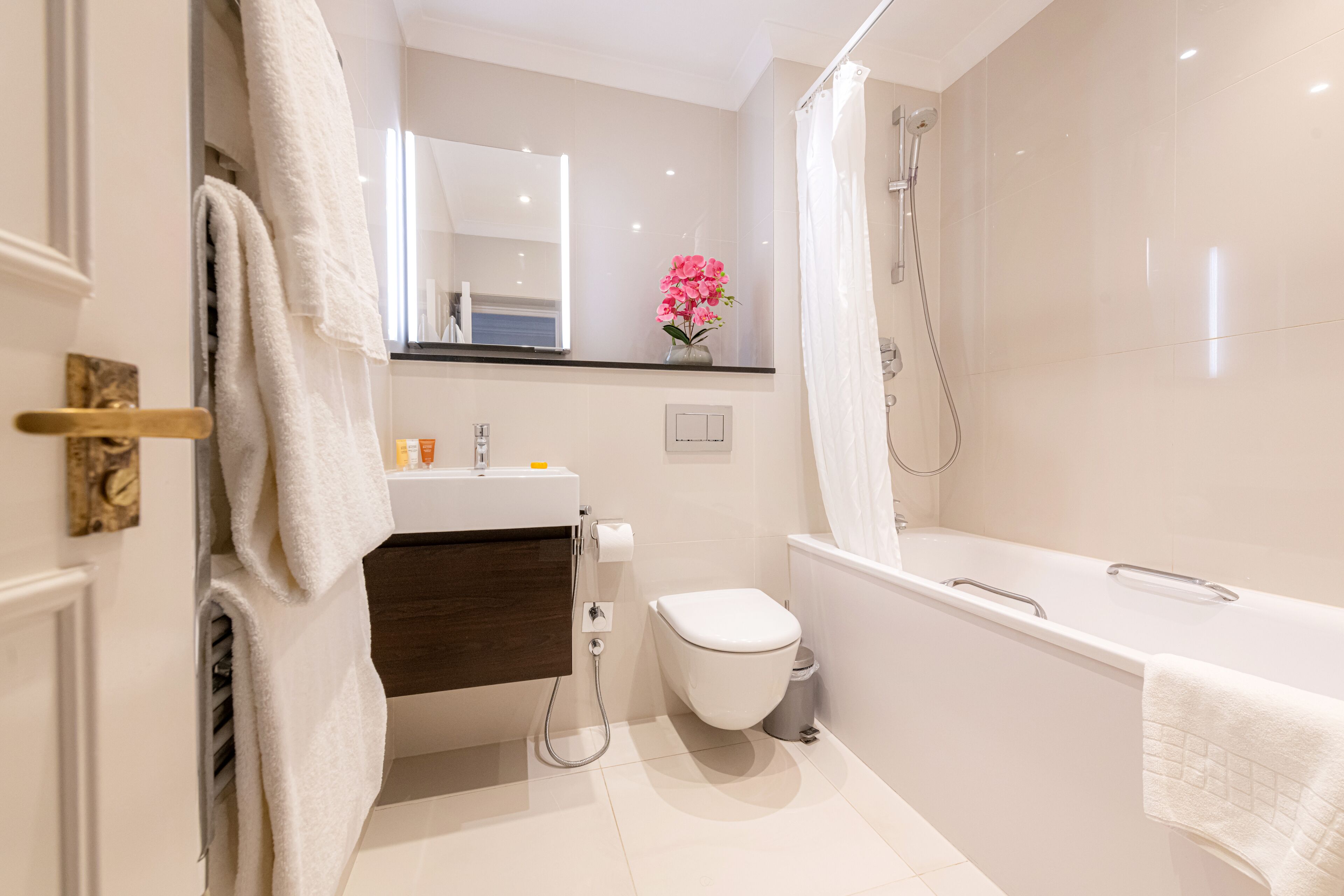 Une salle de bain moderne équipée de toilettes, d’un lavabo et d’une baignoire.