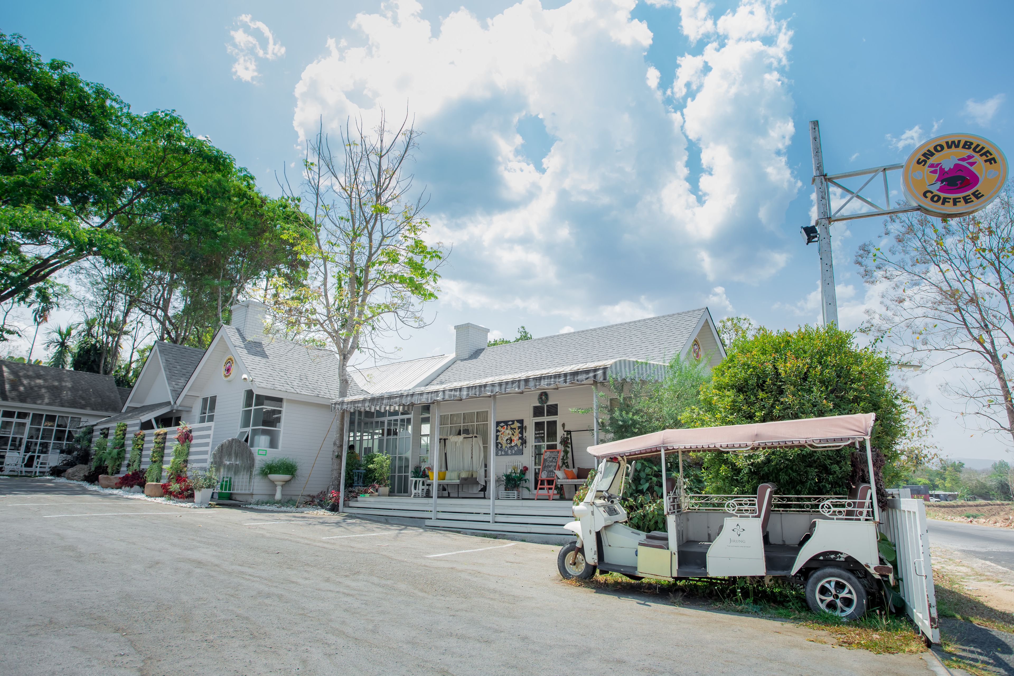 A building with a covered porch and a parked golf cart.