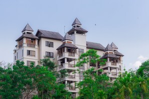 A multi-story building with a symmetrical design, featuring multiple balconies and a central tower.