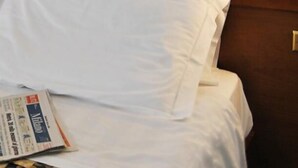 A bed with white linens and a newspaper on it. - Hotel Santorotto (Sinalunga)