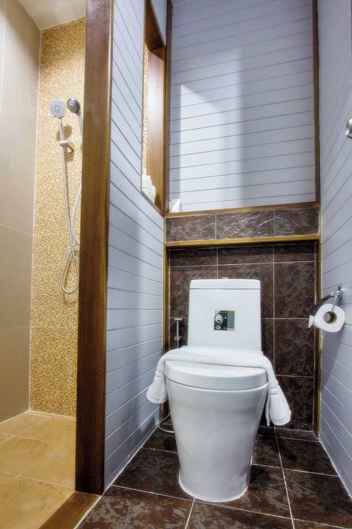 A modern bathroom with a shower, toilet, and marble tiles.