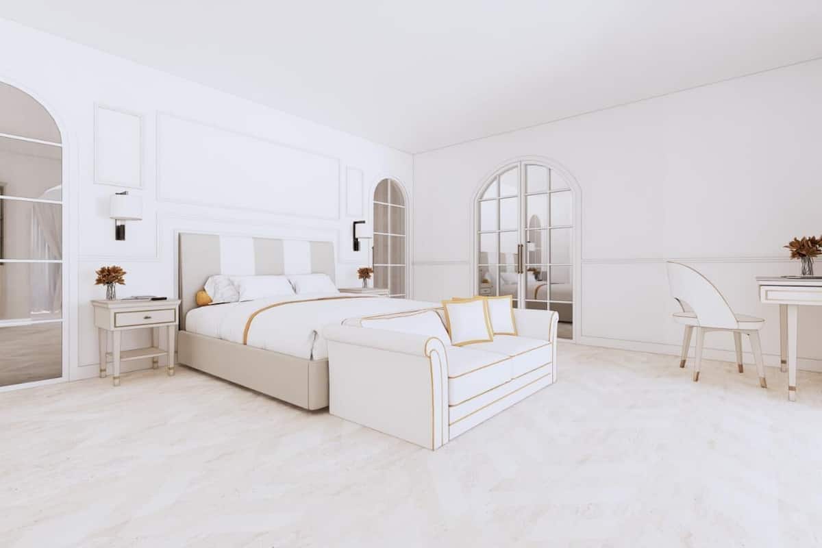 Un dormitorio con cama, mesitas de noche, escritorio y silla.