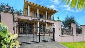 A two-story house with a gated entrance, a balcony, and a well-maintained lawn. - ABC Accommodation - Rosebud (Rosebud)