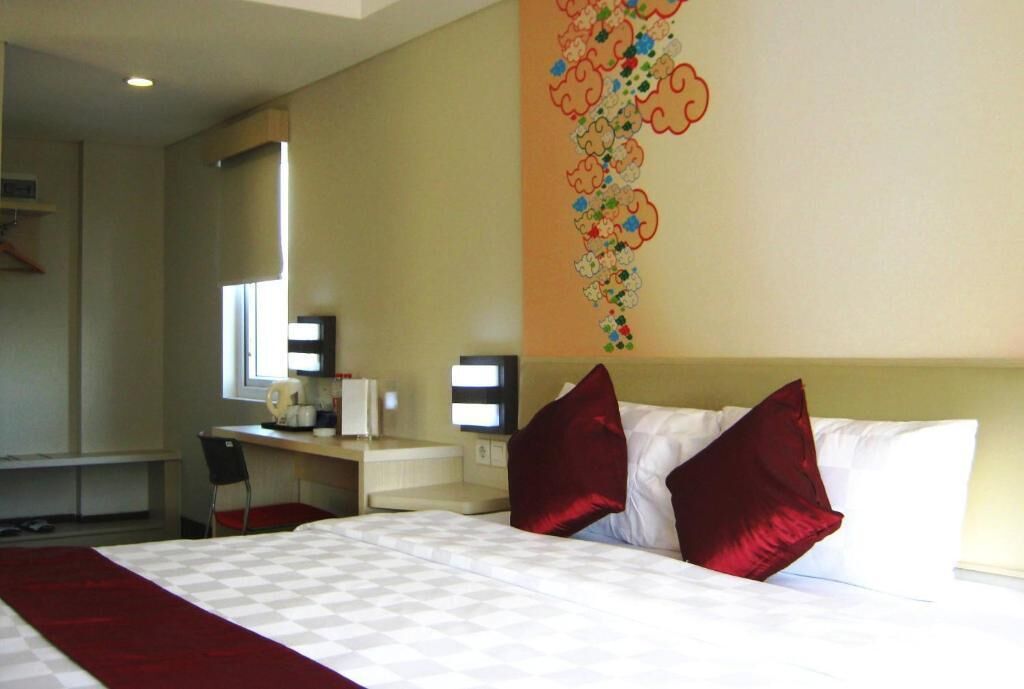 Ein Hotelzimmer mit Bett, Schreibtisch und Stuhl.