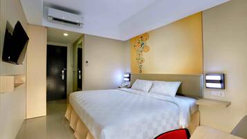 Une chambre d’hôtel moderne dotée d’un grand lit, d’un téléviseur à écran plat fixé au mur, d’un système de climatisation et d’un élément décoratif mural.