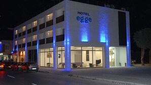 Moderni hotelli, jossa on selkeästi näkyvä, suuri «HOTEL»-kyltti, useita kerroksia ja lasijulkisivu.