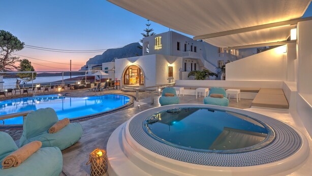 Un resort con piscina, jacuzzi y asientos al aire libre.