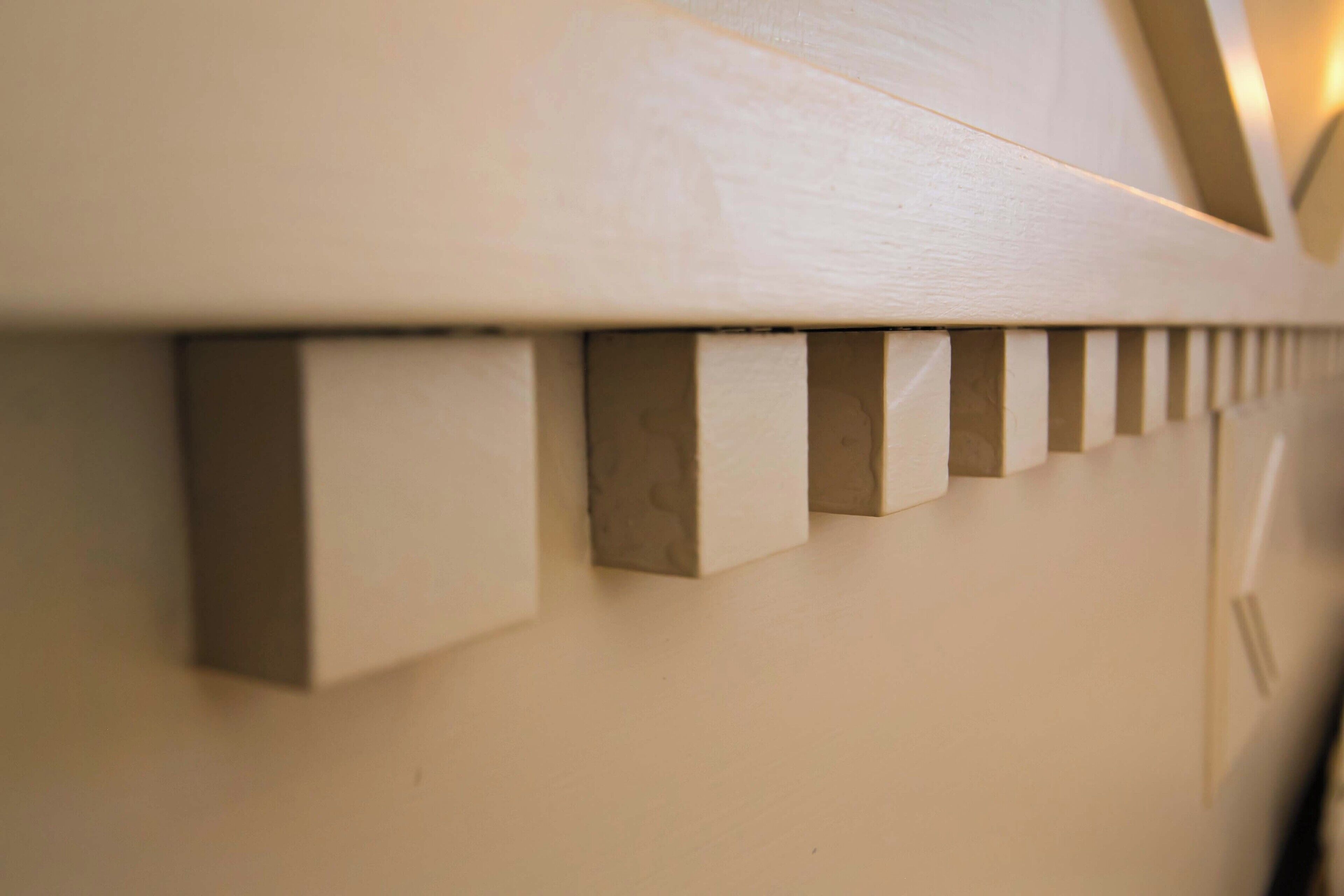 A close-up of a white wooden wall with evenly spaced vertical indentations.