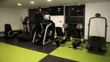 A gym with treadmills, stationary bikes, and weight machines.