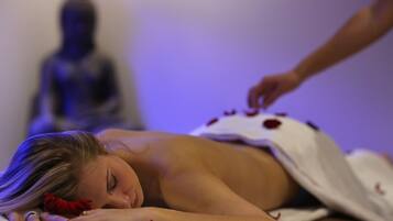 Une personne allongée sur une table de massage, avec une statue en arrière-plan.