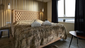 A bedroom with a tufted headboard, a fur-covered bed, a bedside table, and a window with curtains. - Mercure Bale Mulhouse Aeroport (Blotzheim)