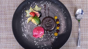Plat de postres amb diversos elements, com ara un pastís de xocolata, freses, figues i una bola de gelat.