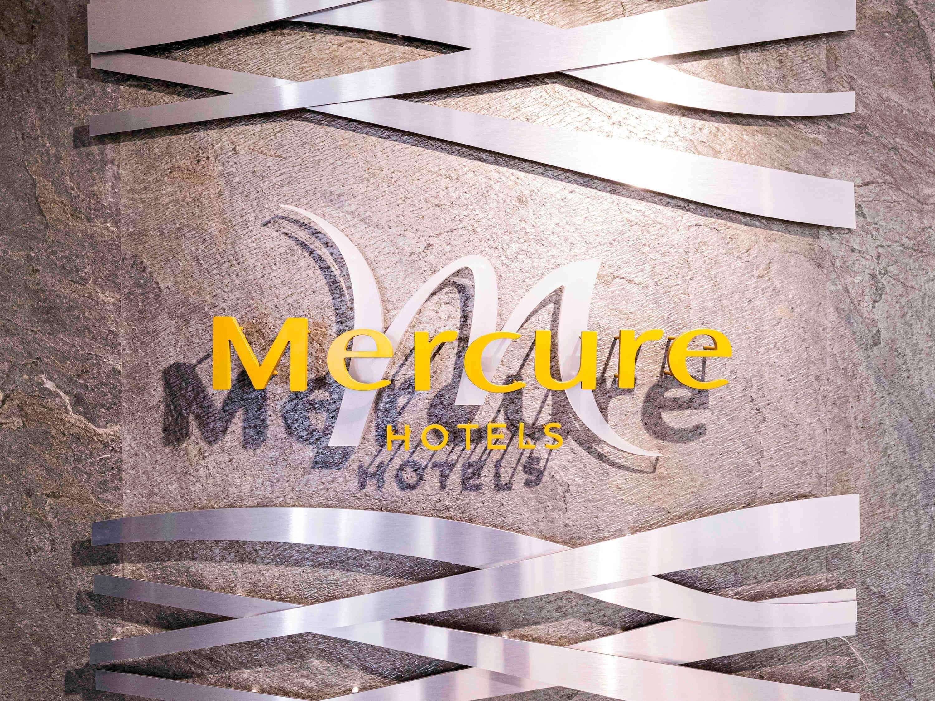 A textured wall with the text "Mercure Hotels" in yellow and black.