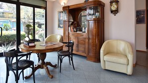 Un comedor con una mesa redonda, sillas, un armario y un reloj en la pared.