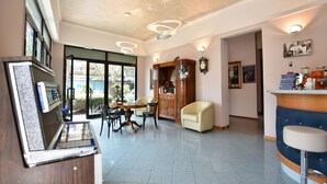 Una habitación amplia con comedor, barra y un ventanal grande.