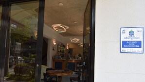 Un restaurante con zona de bar, una mesa de madera y sillas. Hay un cartel en la pared que indica que es un establecimiento para ciclistas.