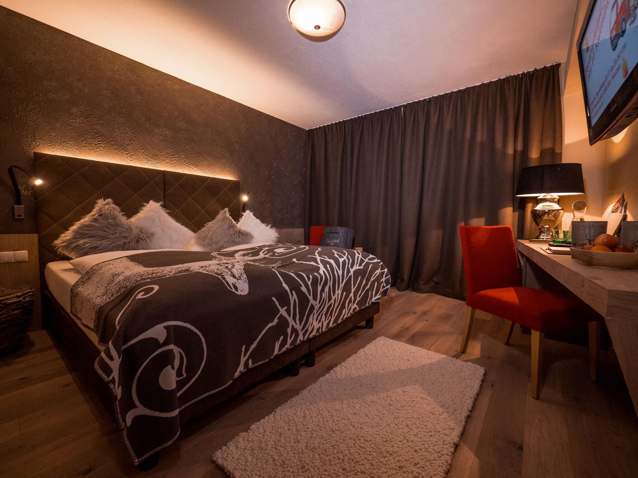 Un dormitorio moderno con cama, escritorio y silla.