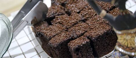 Uma travessa de brownies sobre um prato branco com padrão quadriculado.