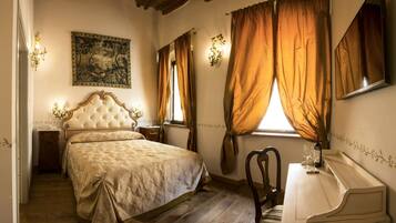 A bedroom with a large bed, a wooden dresser, a chair, and a window with curtains.