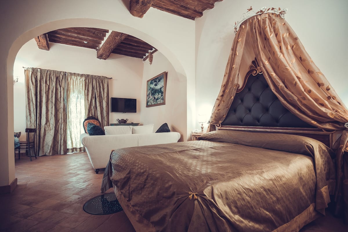 Un dormitorio con una cama grande, un televisor y un cuadro en la pared.