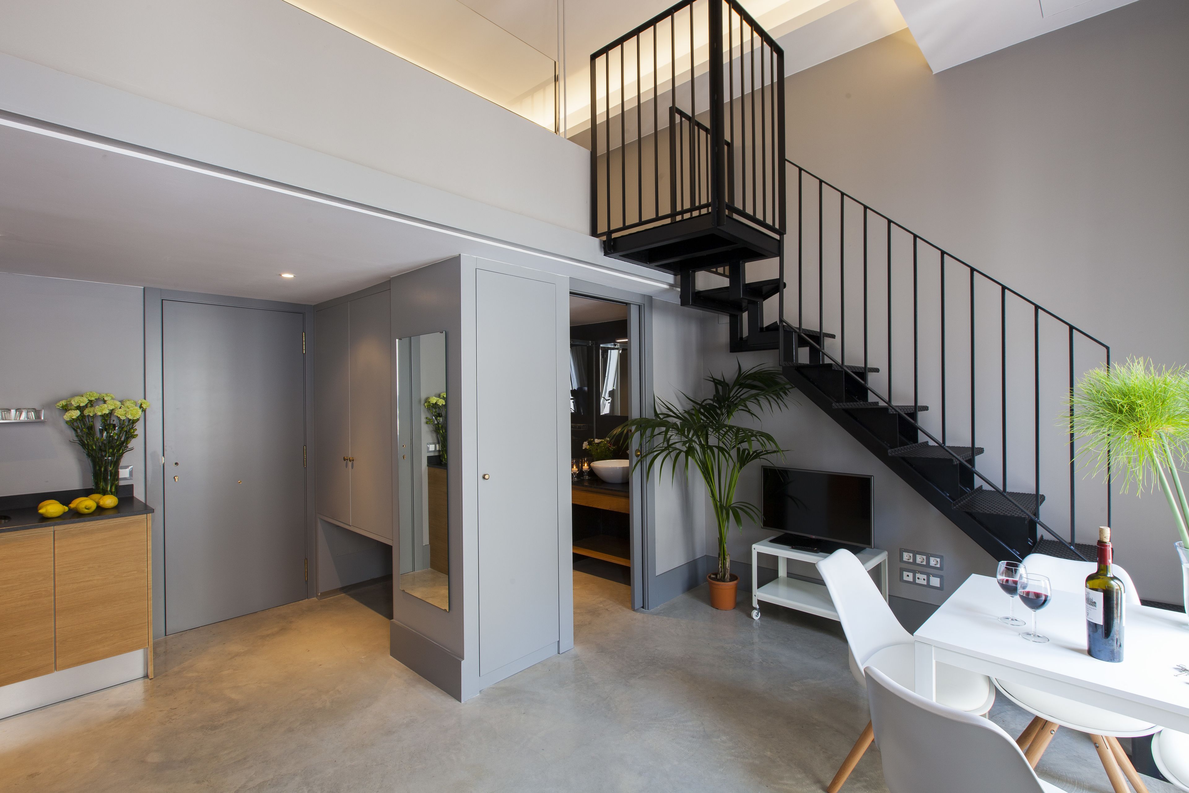 A modern interior with a staircase, a dining area, and a kitchen.
