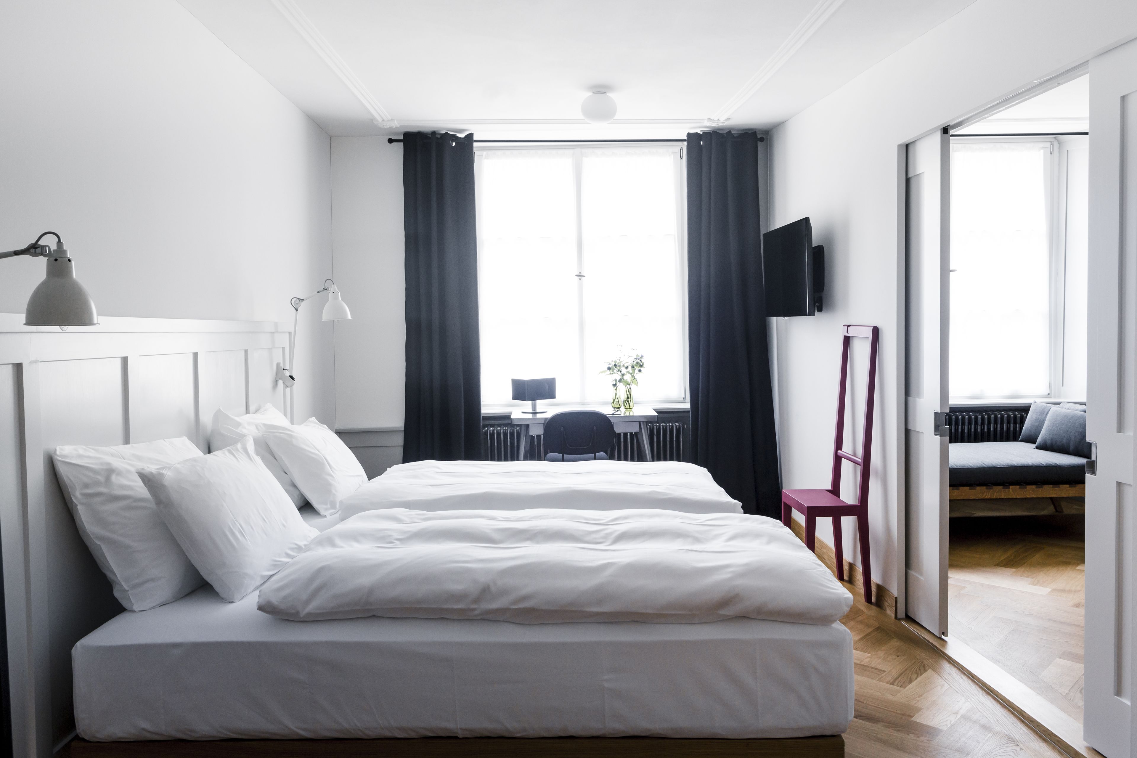 Um quarto moderno com uma cama grande, uma escrivaninha e uma televisão.