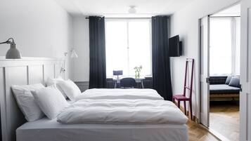 Um quarto moderno com uma cama grande, uma escrivaninha e uma televisão.