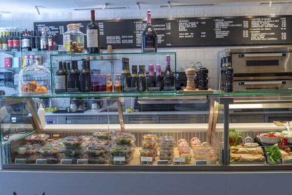 A deli counter with various food items and a wine selection.