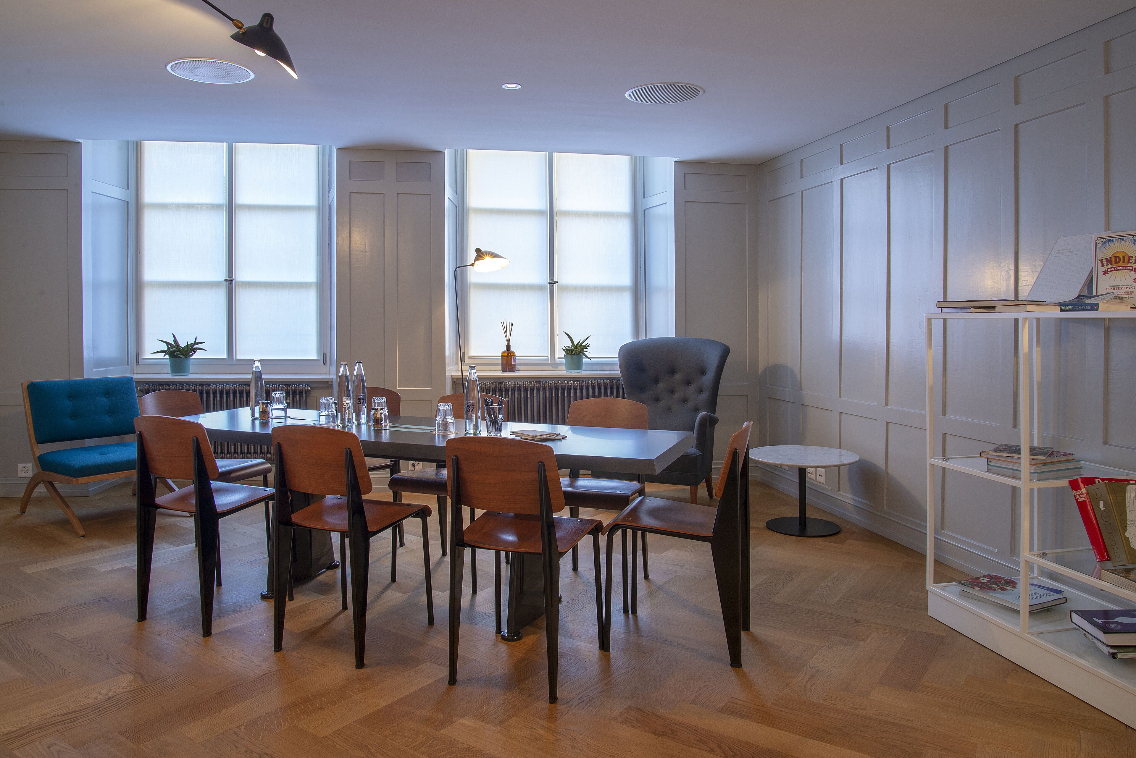 A dining area with a table, chairs, and a bookshelf.
