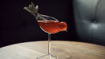 A cocktail in a unique glass on a wooden table.