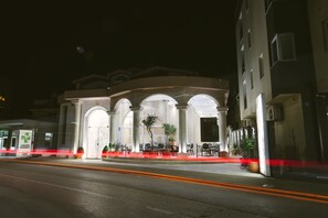 A building with a central courtyard, arched entrances, and outdoor seating areas. - Hotel Flowers (Citluk)