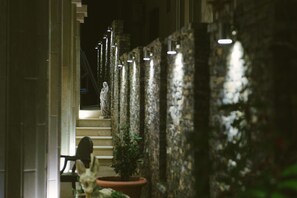 A stone wall with a statue, a staircase, and a potted plant. - Hotel Flowers (Citluk)