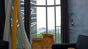 A room with a large window, two woven baskets, a book, and a hat on a sofa. - Bonita Bay Concept Hotel by Xarm Hotels (Santa Marta)