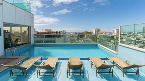 A rooftop pool with lounge chairs, a glass balustrade, and a city view. - Américas Copacabana Hotel (Rio de Janeiro)