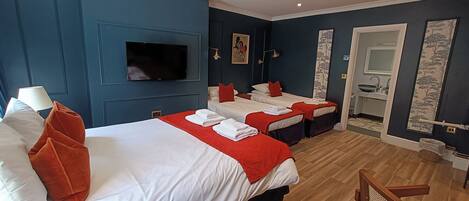 A hotel room with two beds, a TV, a bathroom, and a wooden chair.