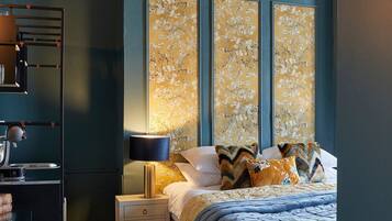 A bedroom with a large bed, a nightstand, a lamp, and a decorative wall panel.