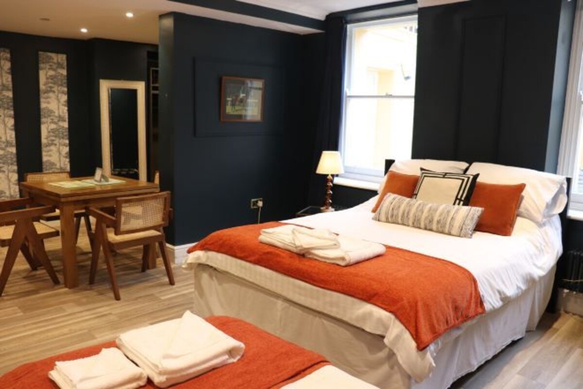 Une chambre d’hôtel avec un lit, un bureau et une chaise.